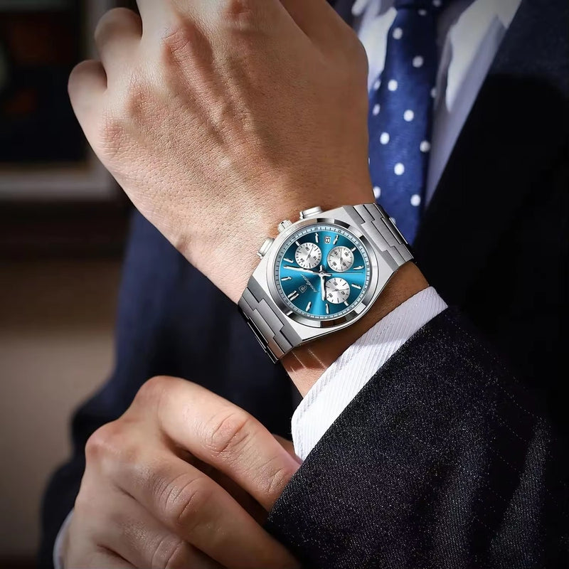 Close-up of a person wearing a silver watch with a blue face, dressed in formal attire.